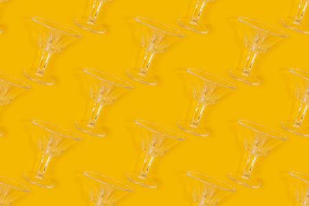 Pattern made of crystal glasses on a yellow background. Creative layout.の写真素材