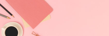 Banner with cup of coffee and copybook on a pink background.の写真素材