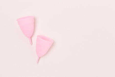 Pink menstrual cups on a gray background. Concept with place for text.の写真素材