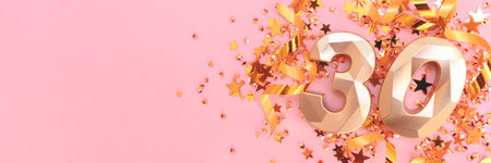 Banner with golden number 30, ribbons and stars confetti on a pink background.の写真素材