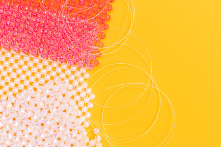 Details for handmade bag made from acrylic beads on a yellow background with copy space.