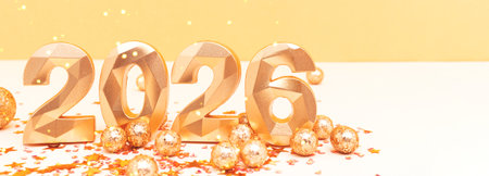 2026 - numbers and confetti in front of beige and golden background. New Year celebration concept...