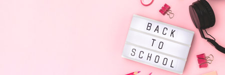 Back to school. Banner with lightbox, headphones and stationery on a pink background.の写真素材