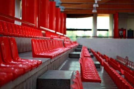 rows of red plastic chairs at sport hallの写真素材