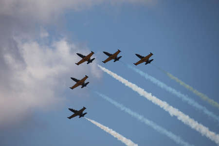 Acrobatic planes with colorful contrails at an air show 
