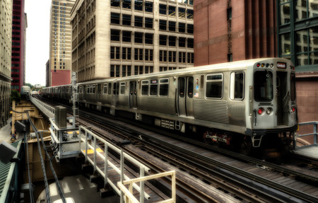 Train on elevated tracks within buildings at the Loop, Chicago City Center - Sepia Glow Artistic Effect - Chicago, Illinois, USAのeditorial素材