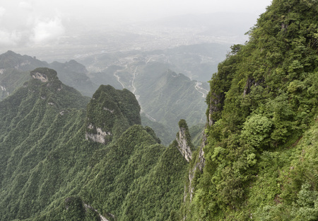 Tianmen Mountain Known as The Heaven's Gate surrounded by the green forest and mist at Zhangjiagie, Hunan Province, China, Asiaの写真素材