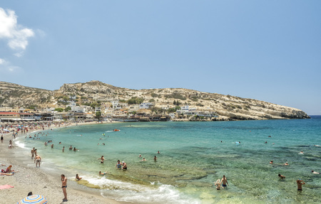 Tourists swimming at Matala beach, Crete Island, Greece - 22 June 2018