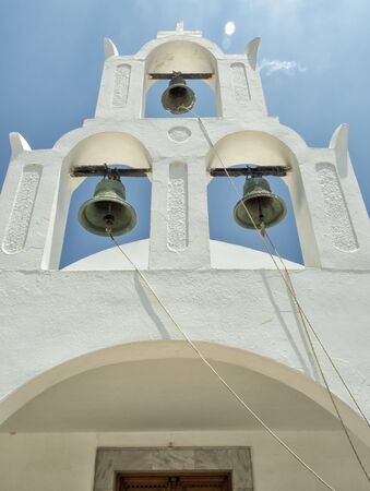 White Church with bells and blue dome at Oia, Santorini, Greek Islandsの写真素材