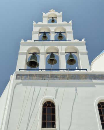 White Church with bells and blue dome at Oia, Santorini, Greek Islandsの写真素材