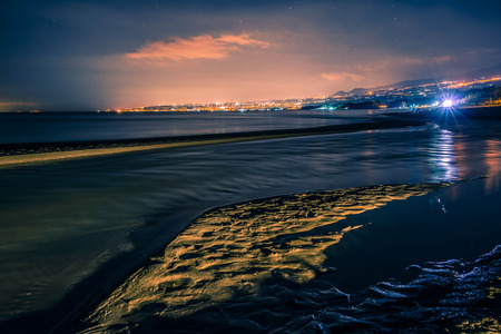 The beautiful east coast of Sicily view at night. The colored cities in the backgroundの写真素材