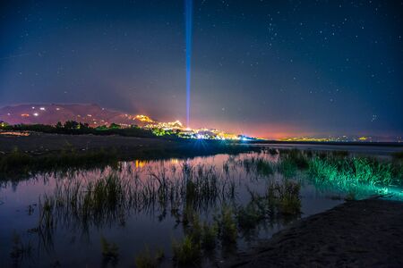 The beautiful east coast of Sicily view at night. The colored cities in the backgroundの写真素材