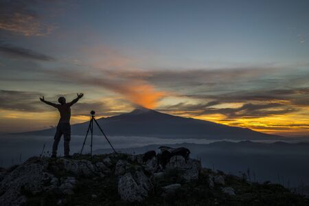 Self portrait. A shot that portrays me in observing my beloved Etna. The wonderful colors of the sunset seen from the Monte Veneretta (ME), Sicily, IT. Uno scatto che mi ritrae nell'osservare la mia amatissima Etna. I meravigliosi colori del tramonto vistの写真素材