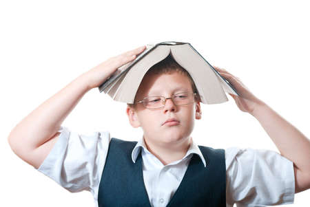 Thoughtful boy with a book on her headの写真素材