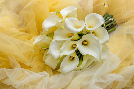 wedding bouquet of white calla lilies on a yellow backgroundの素材