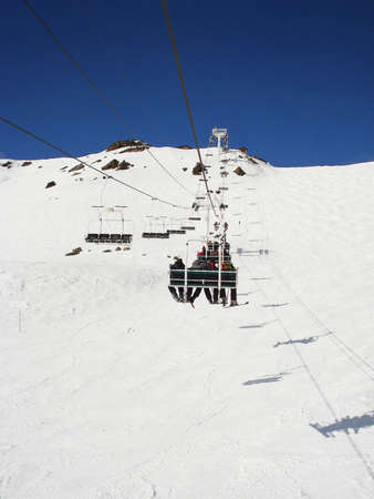 sitting in ski lift with snow mountain view and blue sky                            