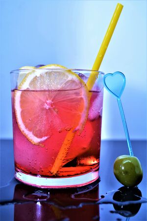 bitter cold aperitif with ice lemon olive red drink italianの写真素材
