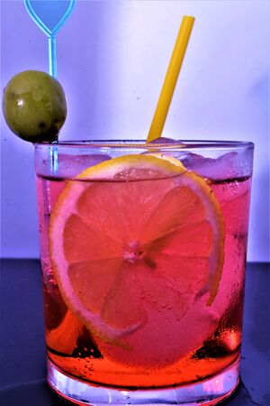 bitter cold aperitif with ice lemon olive red drink italianの写真素材