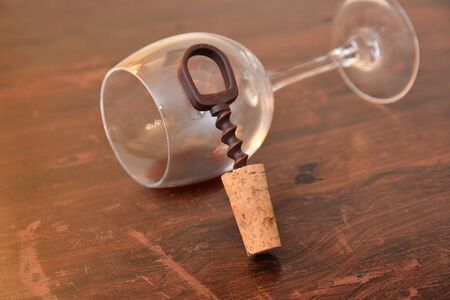 glass with red wine and stopper and corkscrewの写真素材