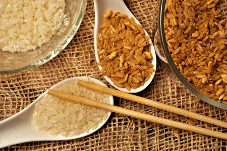white rice and brown rice food on spoonの写真素材