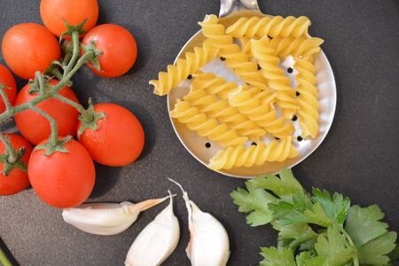 italian pasta fussili with tomato garlic on metal kitchen utensilの写真素材