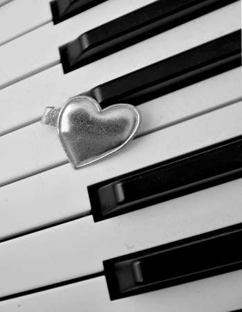 silver heart on a piano keyboard concept of love and passion for musicの写真素材