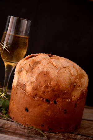 classic italian christmas dessert panettone with glass of italian sparkling wine on black backgroundの写真素材
