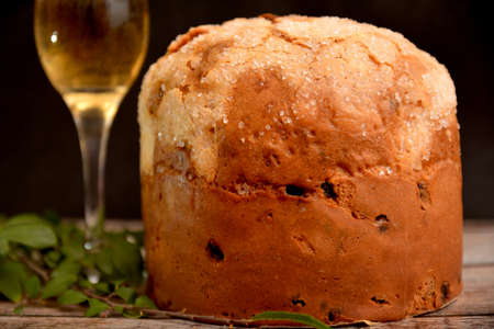 classic italian christmas dessert panettone with glass of italian sparkling wine on black background