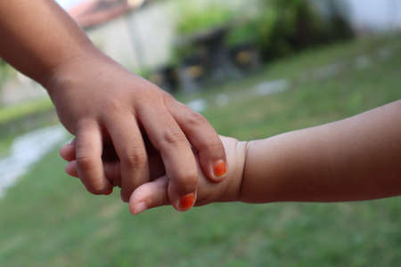 Close up of two sisters holding handsの写真素材