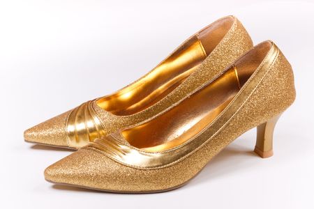golden high-heeled shoes on a white backgroundの写真素材
