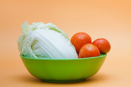 some fresh tomatos,celery cabbage and carrots on a bowlの写真素材