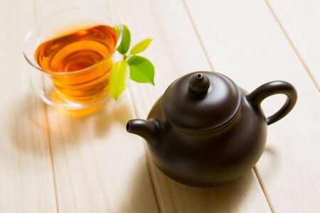teapot and a cup of tea on wooden tableの写真素材