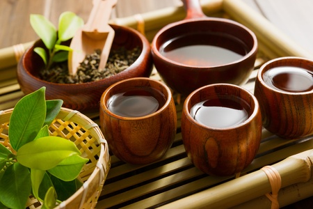 tea and tea leaves on bamboo mat on wooden tableの写真素材