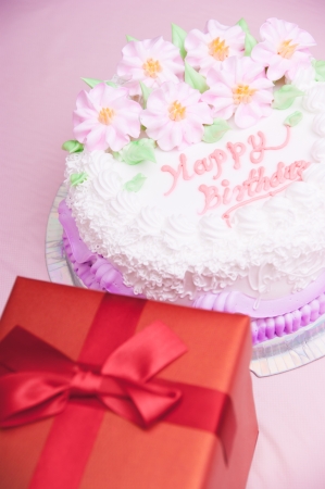 birthday cake and present box on the tableの写真素材