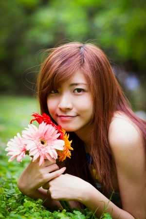Chinese beauty with colorful Africa daisy in the forestの写真素材
