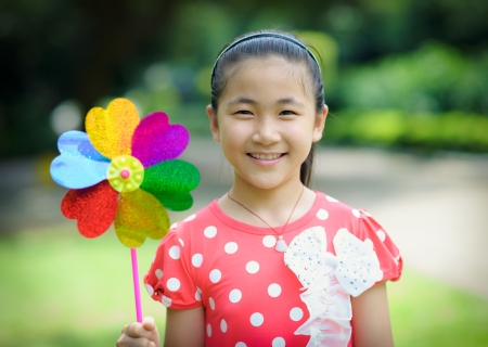 a little girl with the colorful pinwheel out of the doorの写真素材