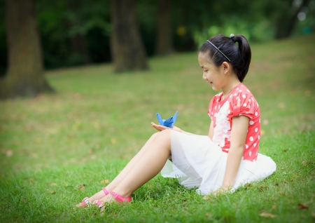 little girl with paper crane out of the doorの写真素材