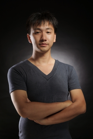 young asian man fine art portrait in photography studio with black backgroundの写真素材