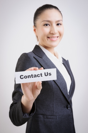 business woman with a paper card with "contact us" on itの写真素材