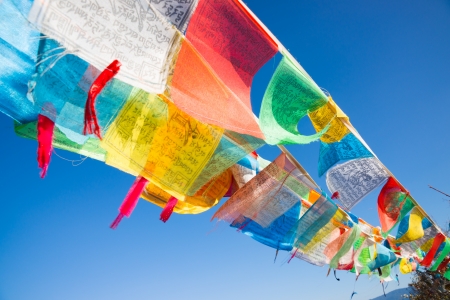 buddhist prayer flags against blue sky in Tibetの写真素材