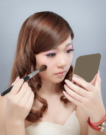 Chinese beauty with professional makeup with brush in photography studioの写真素材