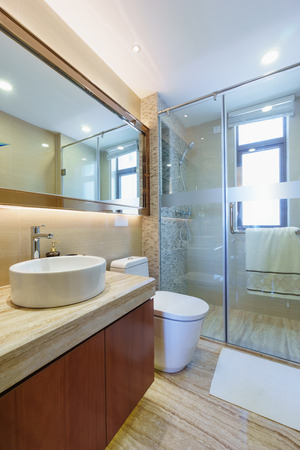 modern bathroom with mirror,cabinet,sink and toiletの写真素材