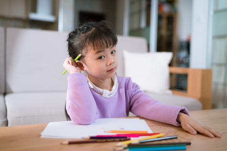 chinese little girl learn to draw on a paper with colour pencilの写真素材