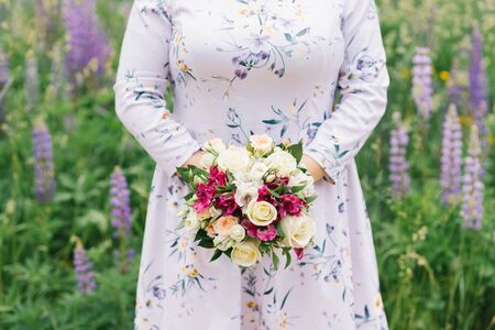 Girl plus size is holding a bouquet of flowers. Wedding bouquet in the hands of the bride. White, pink and Persian flowers.の写真素材