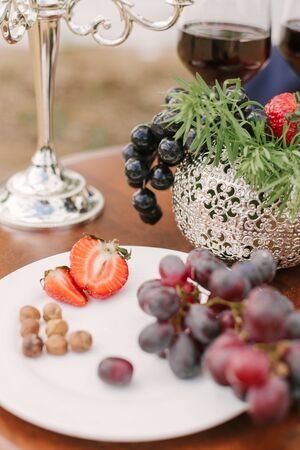 Fruit on a white plate, dessert on a Banquet table in the open air. Selective focusの写真素材