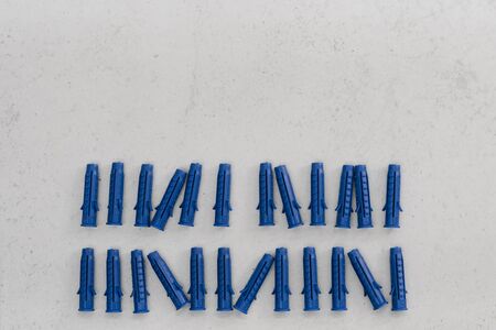 blue plastic dowels on grey background. Fasteners in construction and repair. Copy space for textの写真素材
