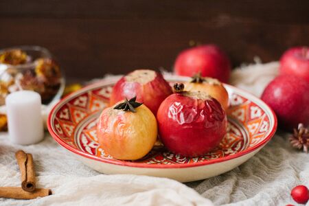 Baked apples on a red patterned plate. Autumn dessert.の写真素材