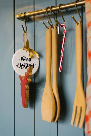 Kitchen wooden spatulas and fork Vit on a hook in the kitchen, cooking accessories, and Christmas tree toys for the New yearの写真素材