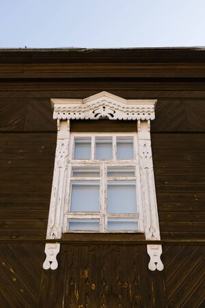 Wooden carved window frame in a wooden Russian houseの写真素材
