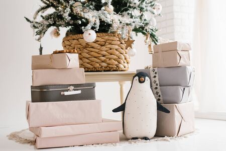 Christmas gifts and a soft toy penguin under the Christmas treeの写真素材